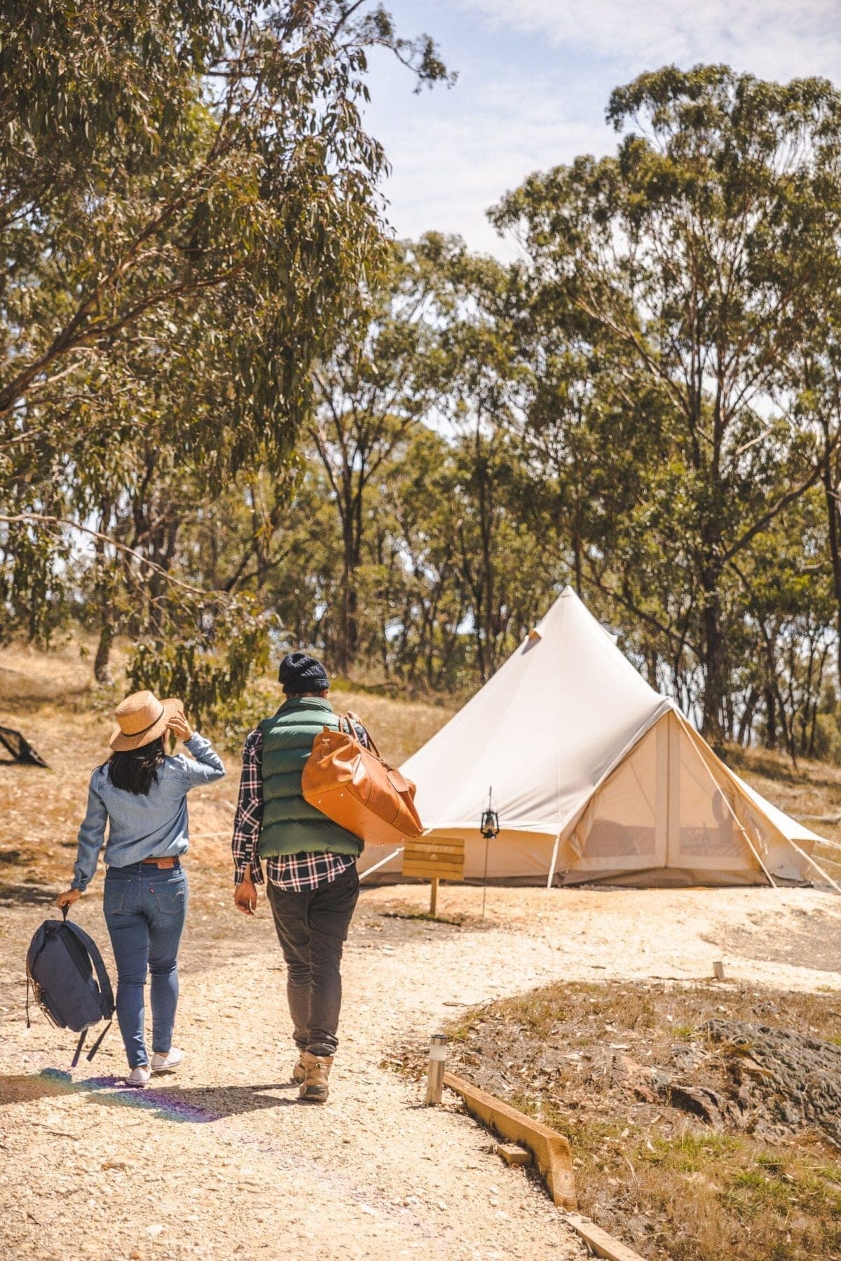 A guest with a guitar on the steps of a bell tent