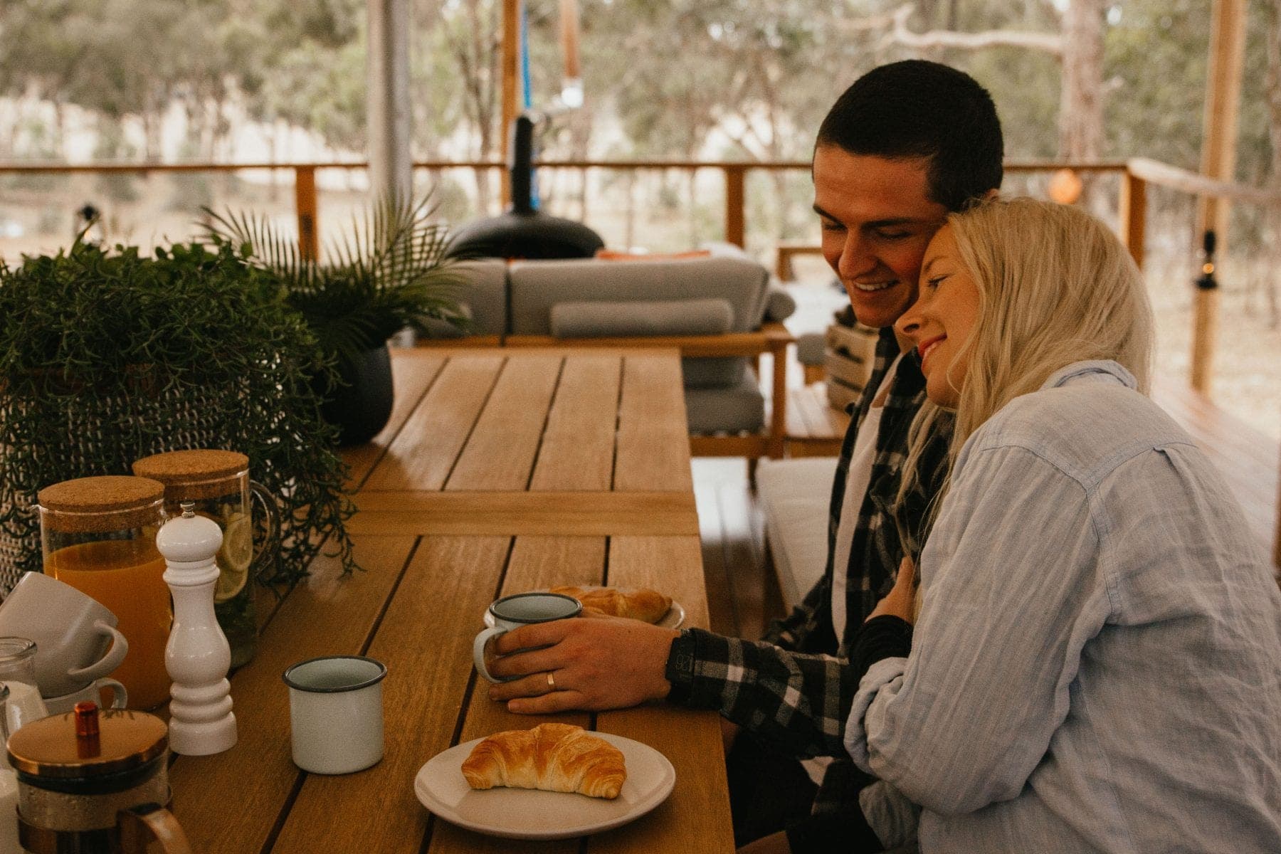 Guests at the camp kitchen table, the bench and shelves behind