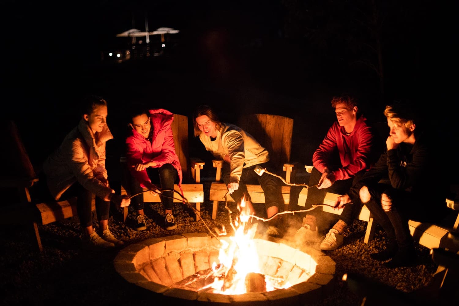 A group of guests around the fire pit at night