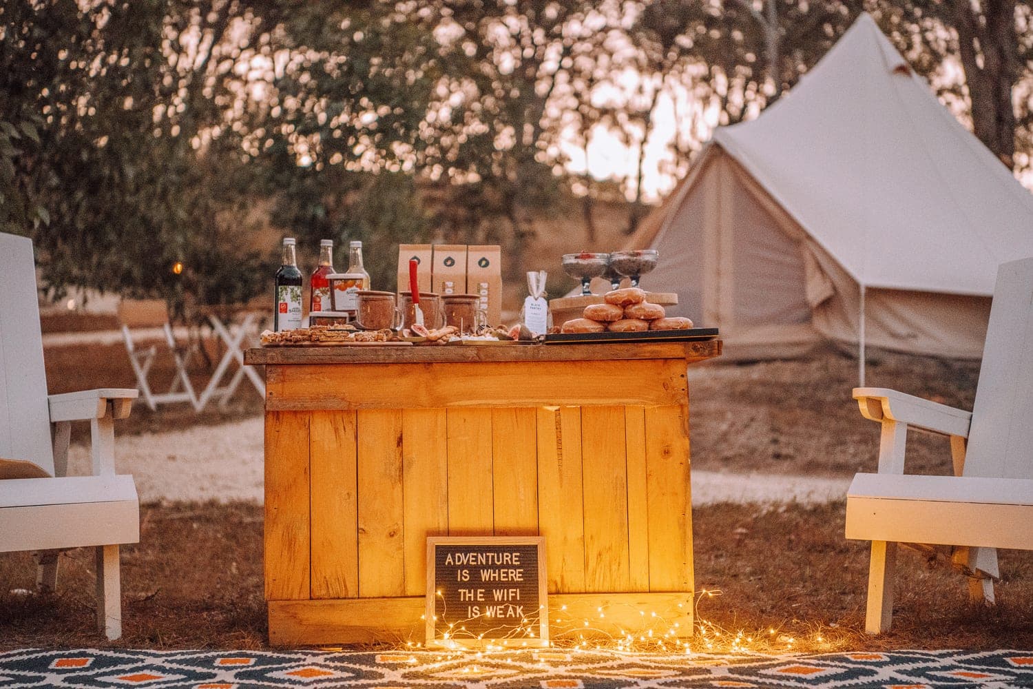 The camp kitchen bench and BBQ, a bell tent behind