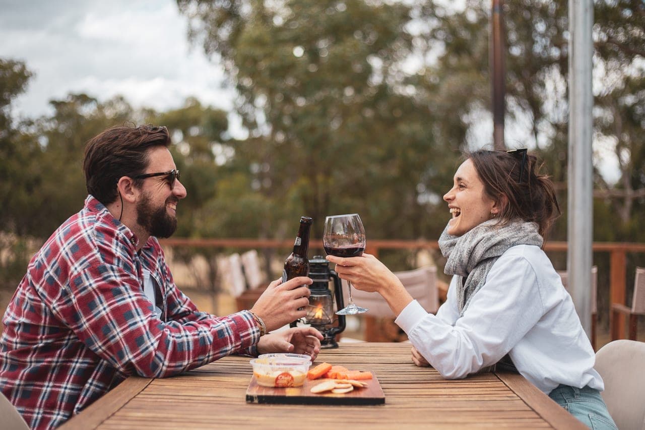 A couple clinking glasses at the camp kitchen table