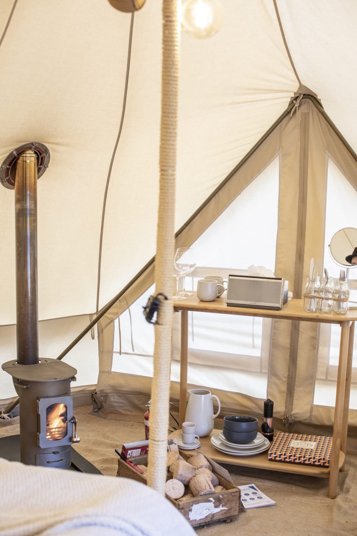 The wood heater lit inside a bell tent on a cold afternoon