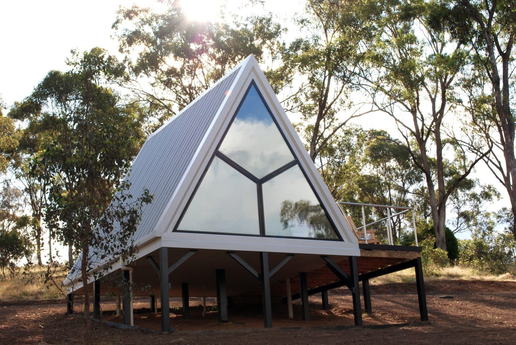 An A-Frame cabin from the front, its glazed gable catching the sky