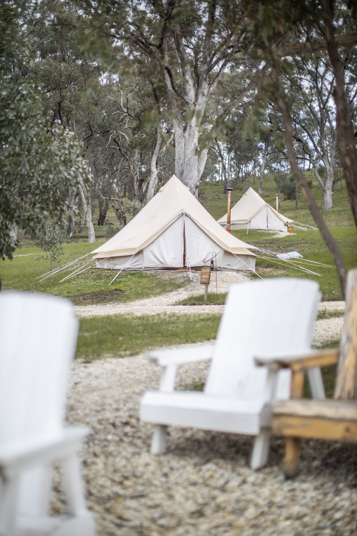 A row of bell tents with a picnic table out front, seen from the path