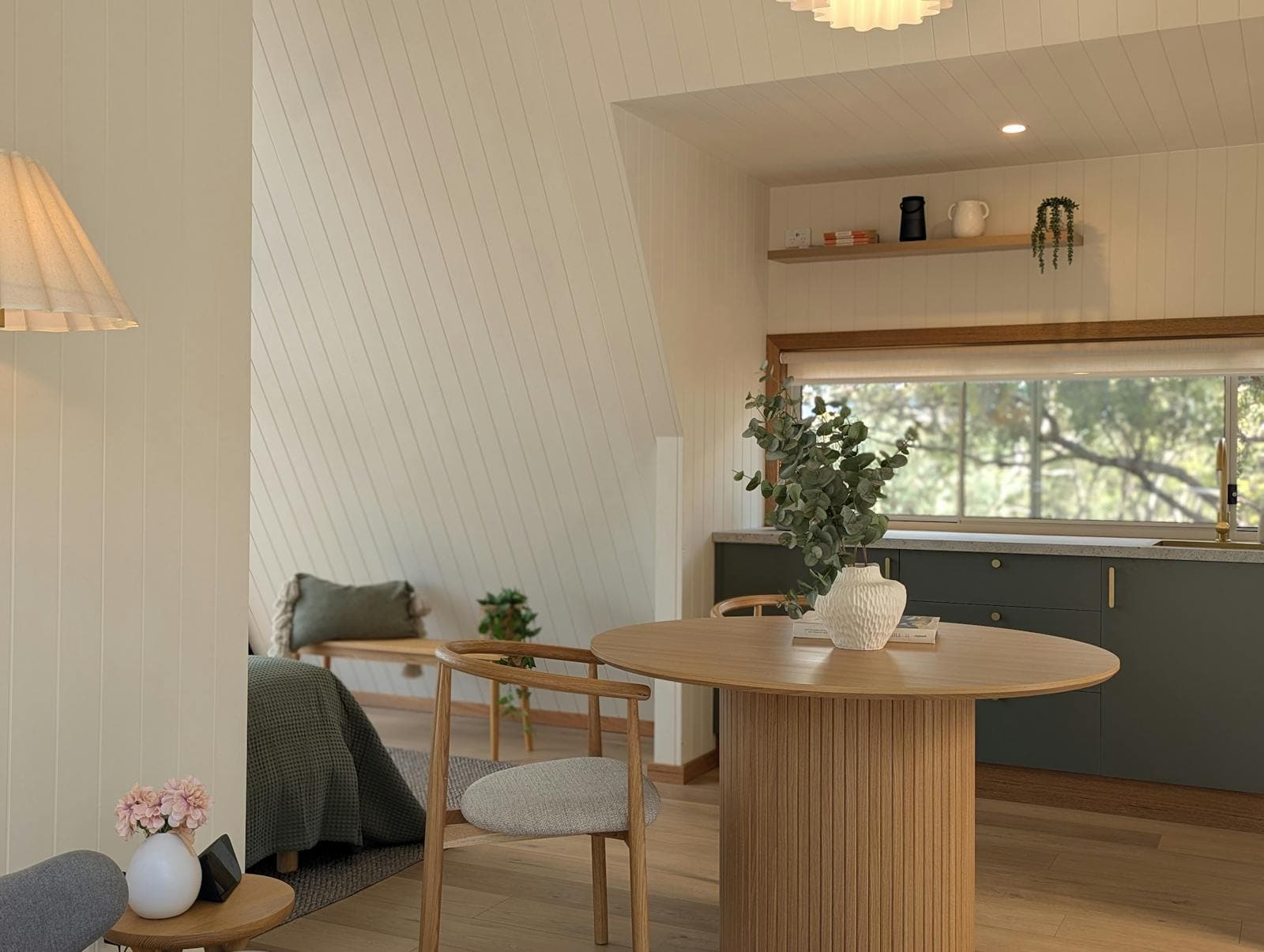 The kitchenette and round dining table inside an A-Frame cabin