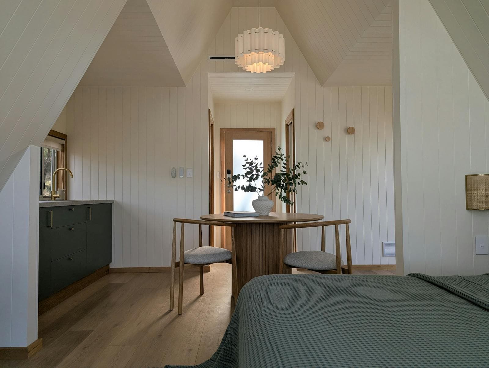 Looking down the cabin from the bed to the kitchenette and the door