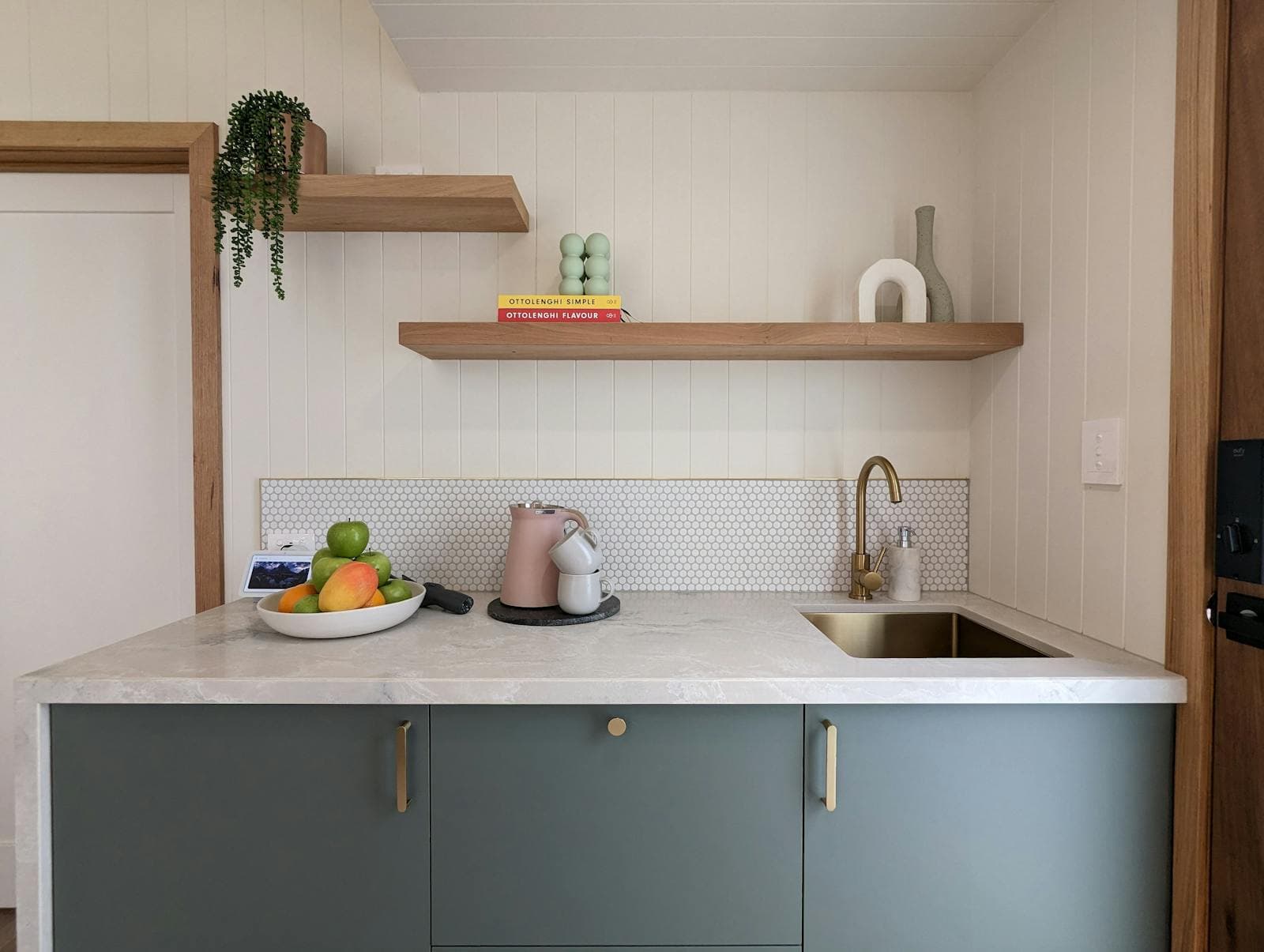 The kitchenette sink and bench, with a bowl of fruit and a kettle