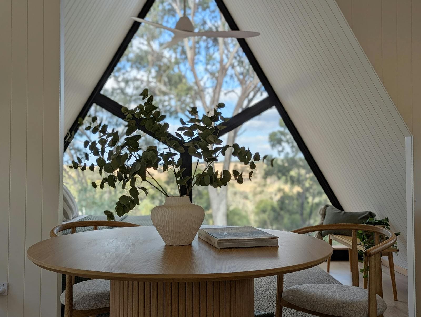 The round table by the cabin window, looking out into the bush