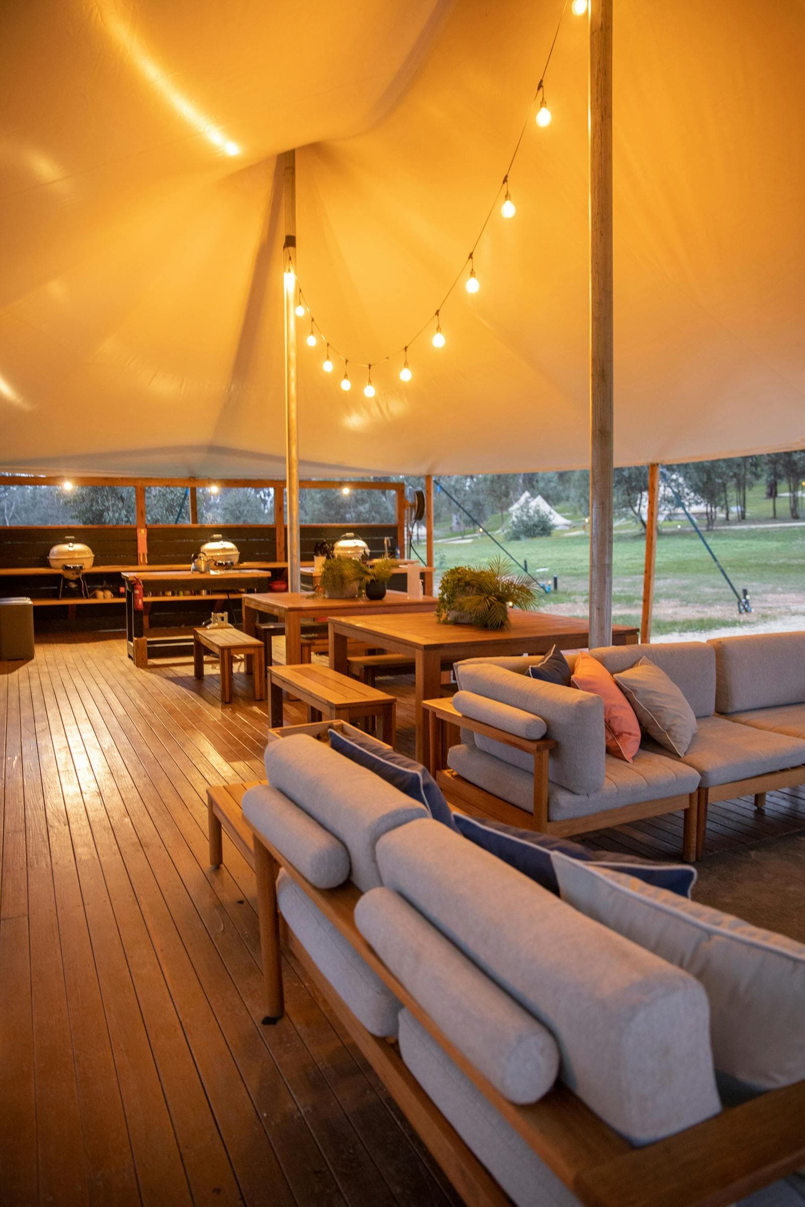 The camp kitchen deck, with lounges and a long timber dining table