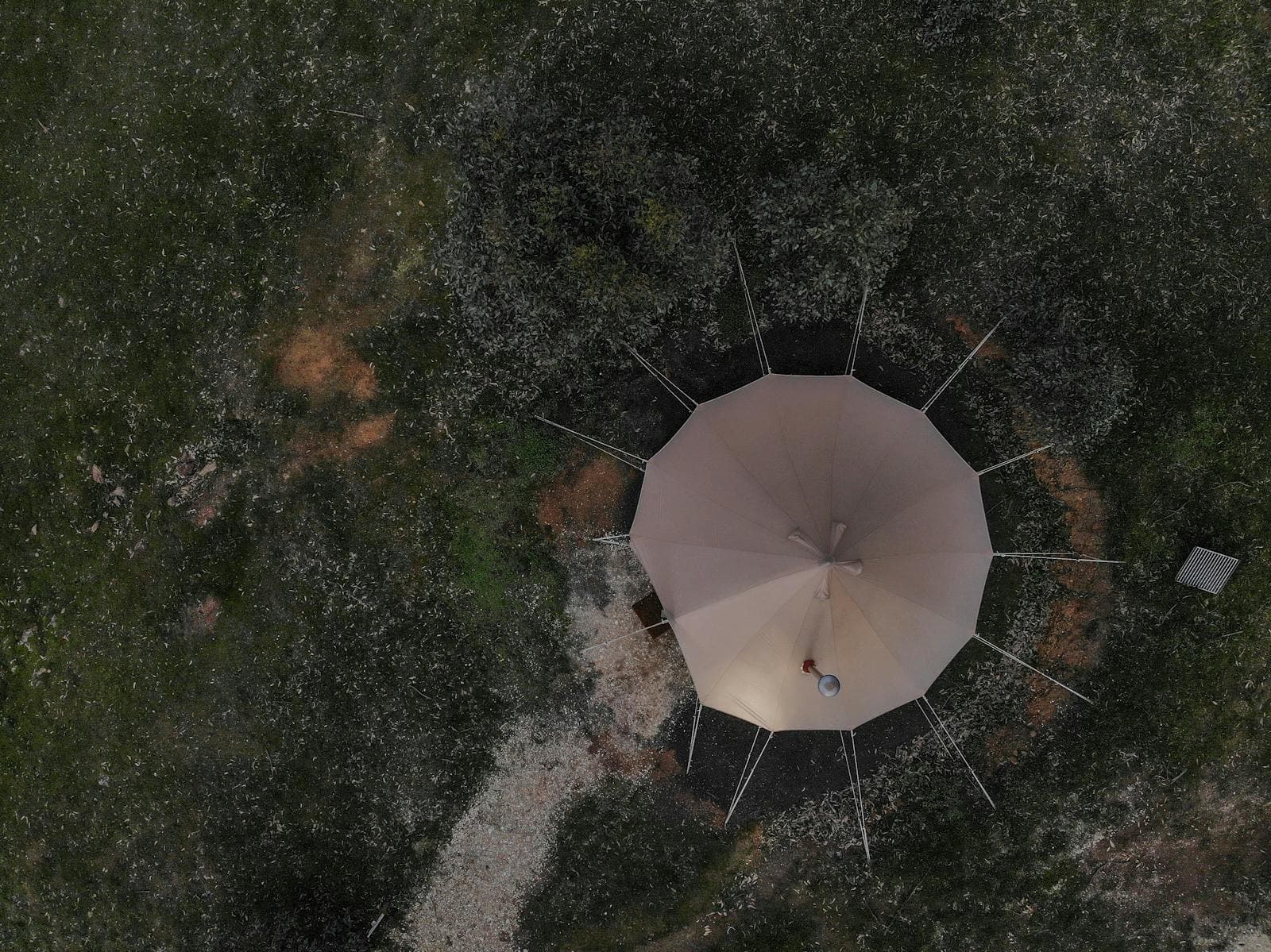 A bell tent seen from directly above at night, glowing from within