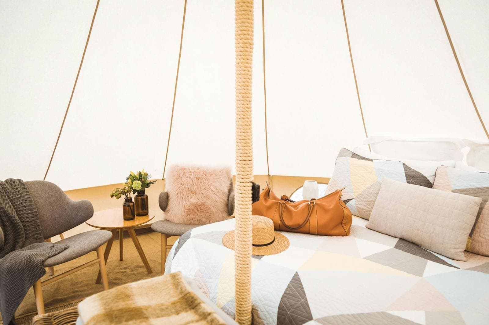 Cushions and a throw on the lounge inside a bell tent